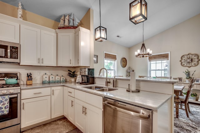 kitchen featuring sink, a notable chandelier, white cabinets, lofted ceiling, and appliances with stainless steel finishes