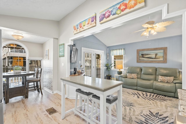 interior space featuring ceiling fan, light wood-type flooring, lofted ceiling, and french doors