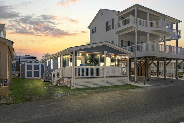 view of front of house featuring a porch, a storage shed, and central air condition unit