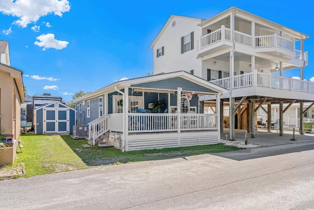 view of front of property with a front lawn, a porch, and a storage unit