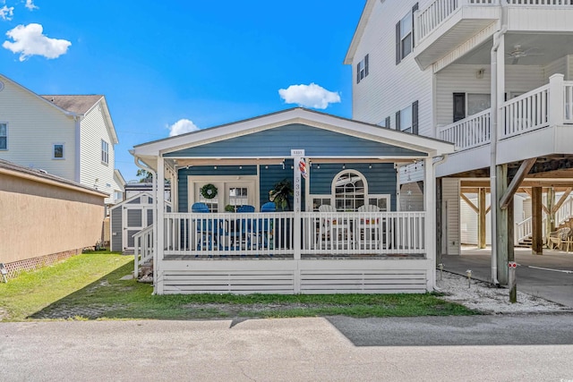 view of front of home featuring a porch and a storage unit