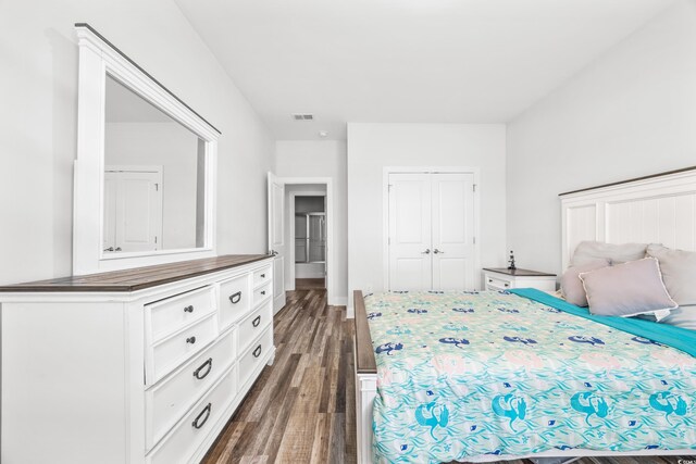 bedroom with dark wood-type flooring and a closet