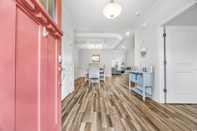 entrance foyer with wood-type flooring, ornamental molding, and coffered ceiling