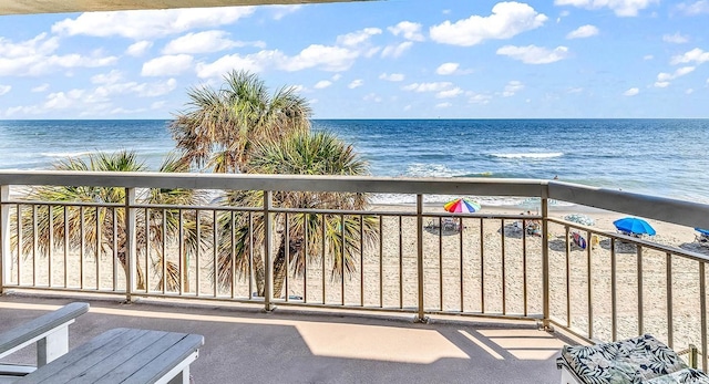 balcony featuring a water view and a view of the beach