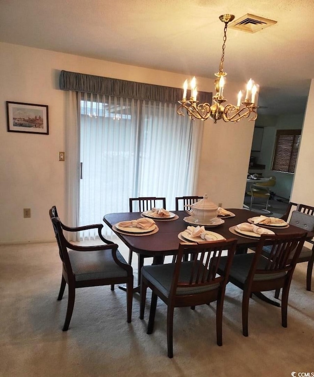 dining space featuring carpet flooring and a chandelier