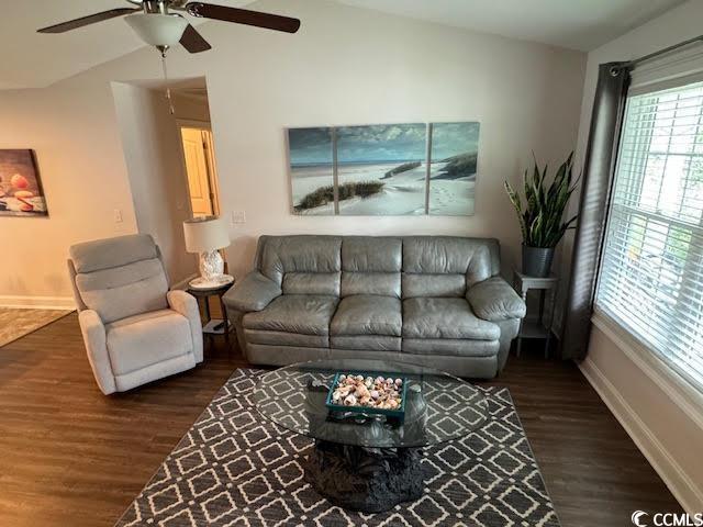 living room featuring ceiling fan, dark wood-type flooring, and lofted ceiling