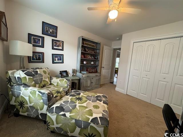 bedroom with ceiling fan, light carpet, and a closet