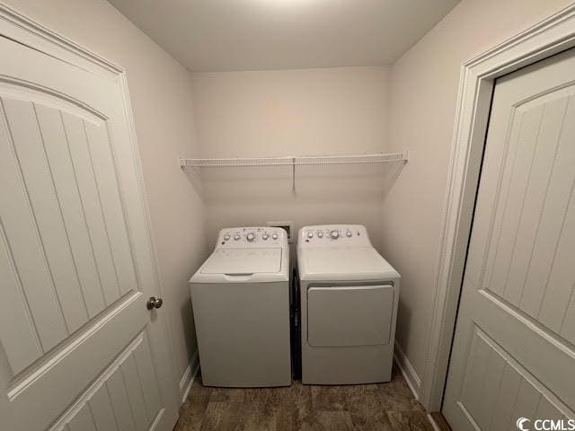 laundry area with independent washer and dryer and dark wood-type flooring