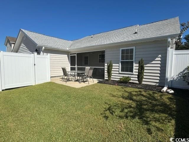 rear view of house featuring a lawn and a patio