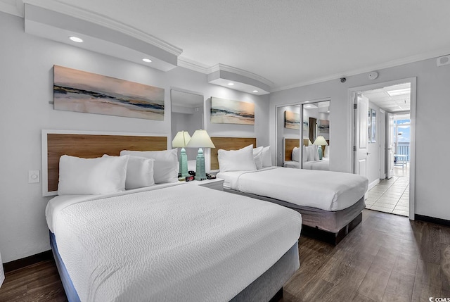 bedroom with ornamental molding and dark hardwood / wood-style floors