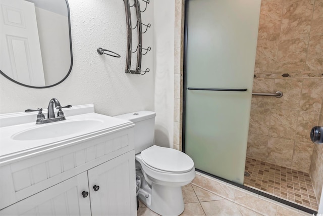 bathroom with vanity, tile patterned flooring, toilet, and a shower with door