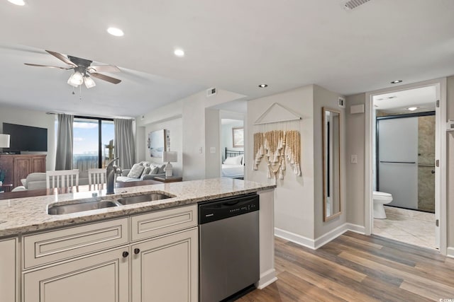 kitchen with light stone counters, dishwasher, ceiling fan, dark hardwood / wood-style floors, and sink