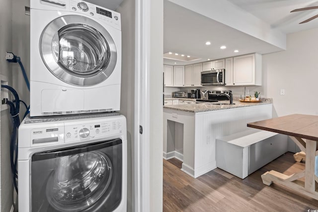 washroom with stacked washer and dryer, hardwood / wood-style floors, and ceiling fan