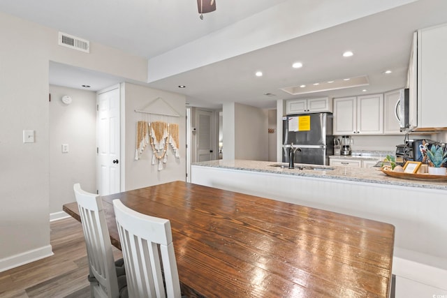 dining room featuring a raised ceiling, dark hardwood / wood-style floors, and sink