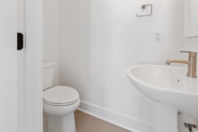 bathroom with sink, toilet, and tile patterned floors