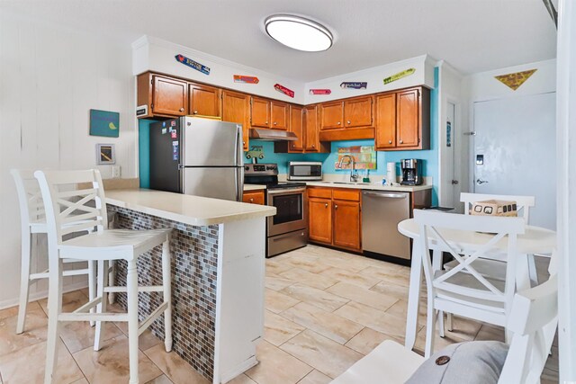 kitchen with sink, stainless steel appliances, and a breakfast bar