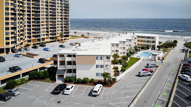 birds eye view of property with a water view and a beach view