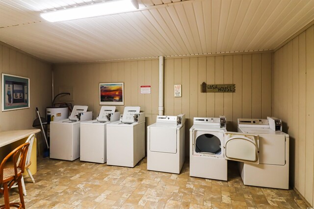 laundry room with wooden walls, wooden ceiling, and washing machine and clothes dryer