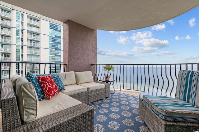 balcony featuring outdoor lounge area and a water view