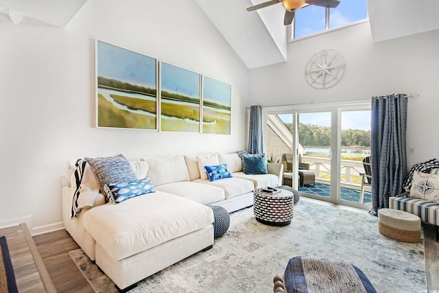 living room with a healthy amount of sunlight, hardwood / wood-style floors, ceiling fan, and high vaulted ceiling