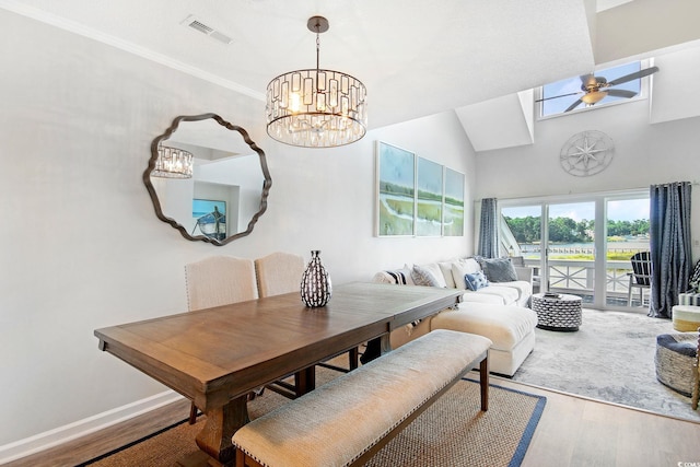 dining room featuring ceiling fan with notable chandelier, high vaulted ceiling, hardwood / wood-style flooring, and ornamental molding