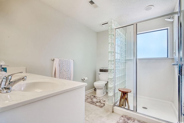 bathroom with tile patterned flooring, vanity, toilet, and a shower with shower door