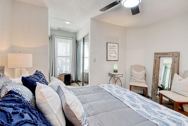 bedroom with ceiling fan, a textured ceiling, a closet, and light hardwood / wood-style floors