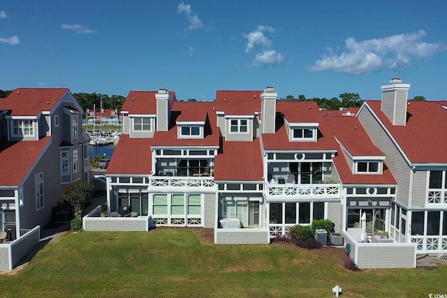 rear view of house featuring cooling unit, a sunroom, and a lawn