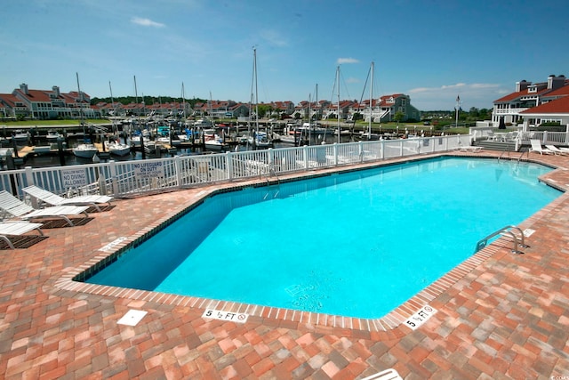 view of pool with a water view and a patio area