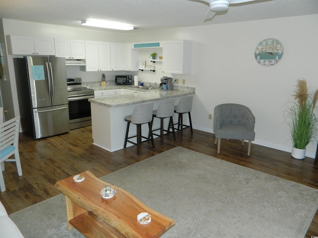 kitchen featuring white cabinets, kitchen peninsula, stainless steel appliances, ceiling fan, and dark hardwood / wood-style floors