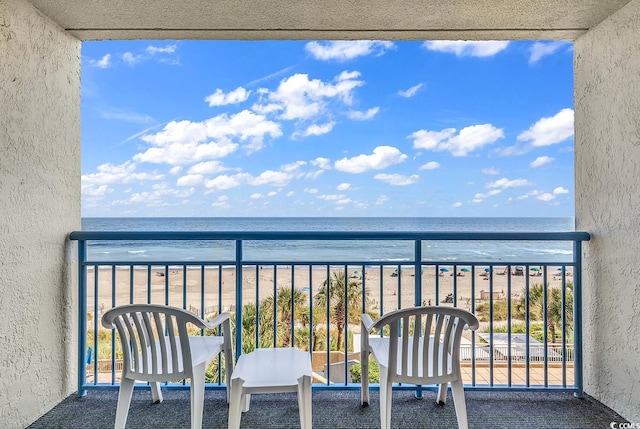 balcony with a water view and a beach view