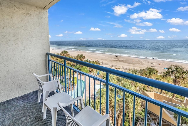 balcony with a water view and a beach view