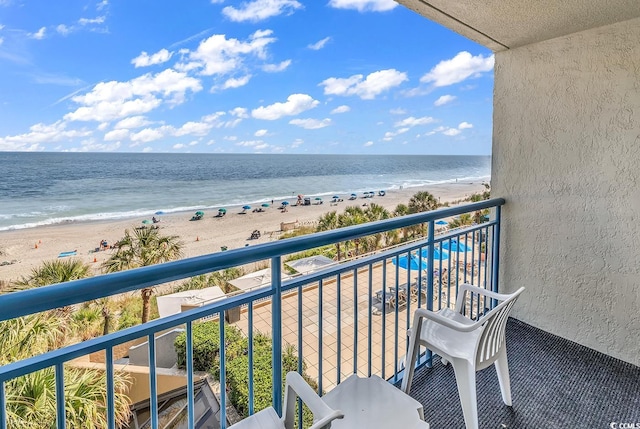 balcony featuring a beach view and a water view