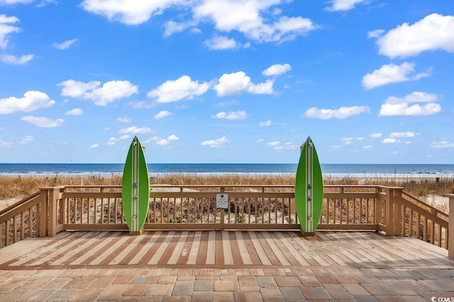 wooden deck with a view of the beach and a water view