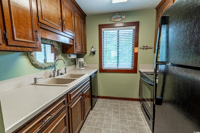 kitchen featuring a textured ceiling, black appliances, and sink