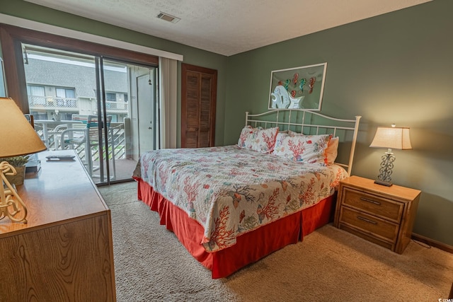 carpeted bedroom featuring a textured ceiling, a closet, and access to exterior