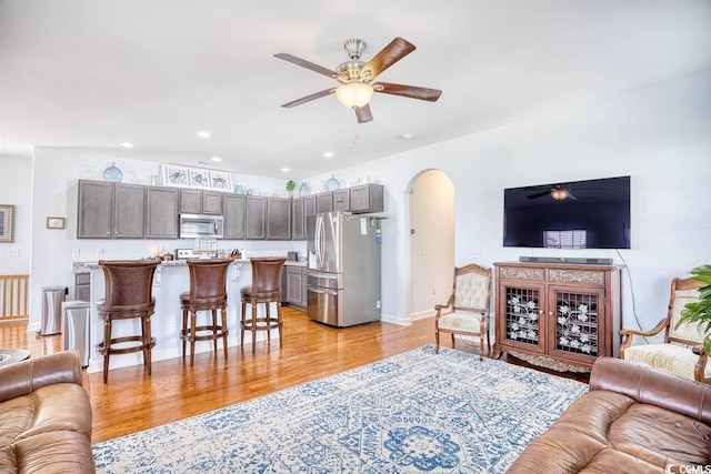 living room featuring ceiling fan and light hardwood / wood-style flooring