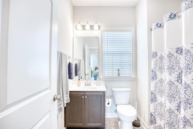 bathroom with a shower with curtain, vanity, toilet, and tile patterned floors