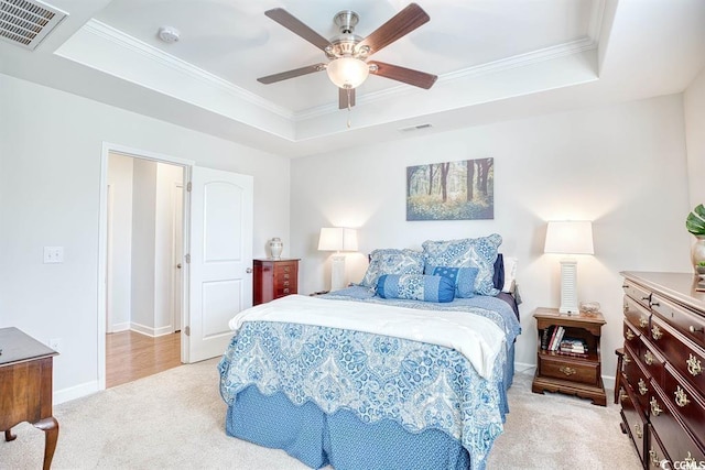 carpeted bedroom featuring ceiling fan, a raised ceiling, and ornamental molding