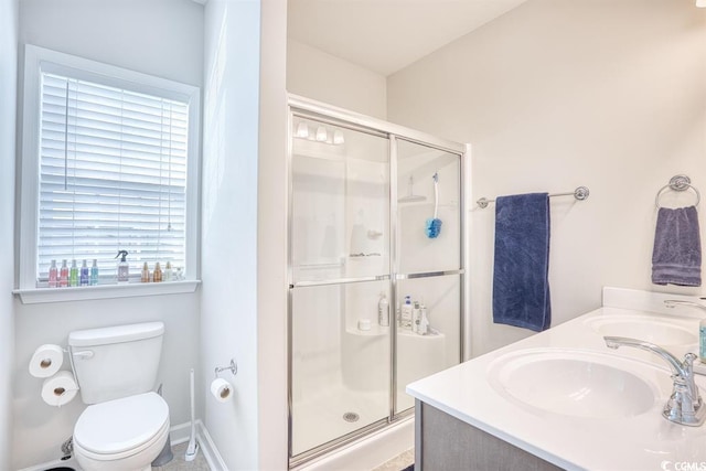 bathroom with a shower with door, vanity, and toilet