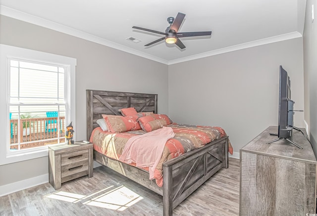 bedroom featuring light wood-type flooring, crown molding, and ceiling fan