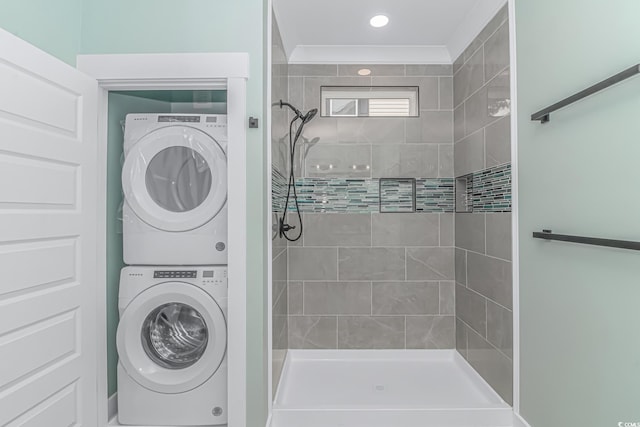 full bath with stacked washer / drying machine and a tile shower