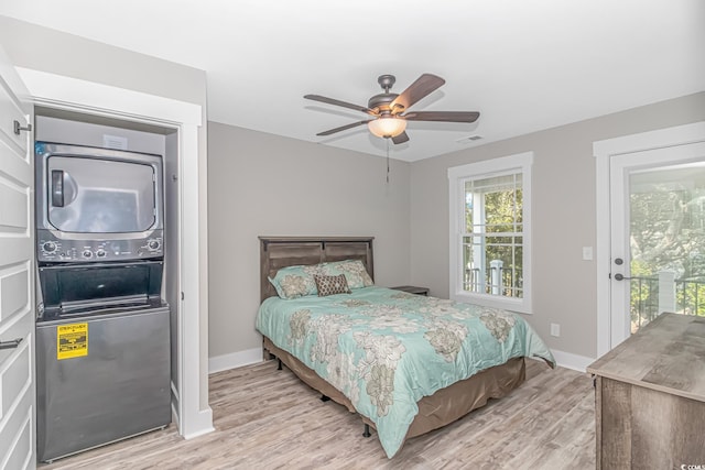 bedroom with ceiling fan, light wood-type flooring, stacked washer and dryer, and access to outside