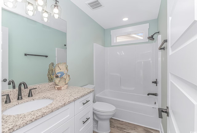 full bathroom with hardwood / wood-style flooring, vanity, toilet, and  shower combination