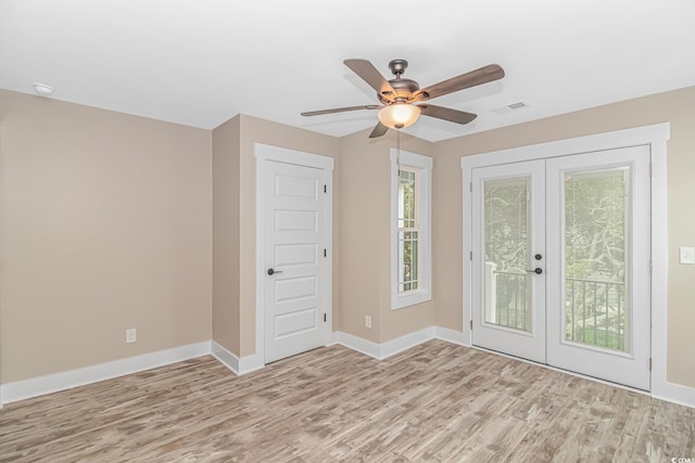 empty room featuring french doors, light wood-type flooring, and ceiling fan