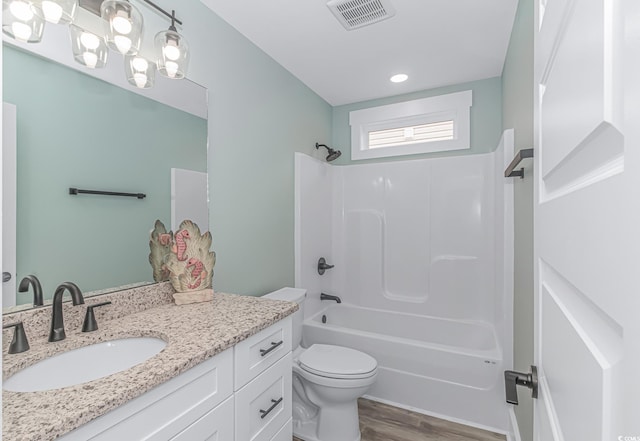 full bathroom with vanity, toilet, wood finished floors,  shower combination, and visible vents