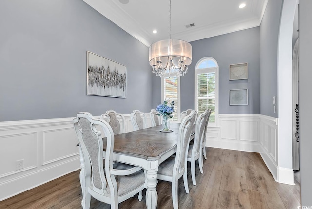 dining room featuring ornamental molding, an inviting chandelier, and light hardwood / wood-style floors