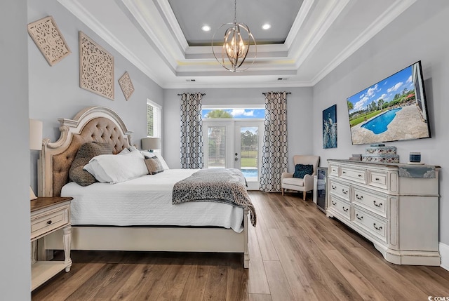 bedroom featuring crown molding, an inviting chandelier, light hardwood / wood-style flooring, and access to exterior