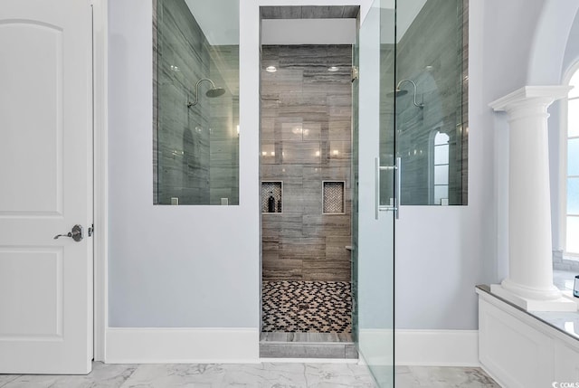 bathroom featuring a shower with shower door and ornate columns