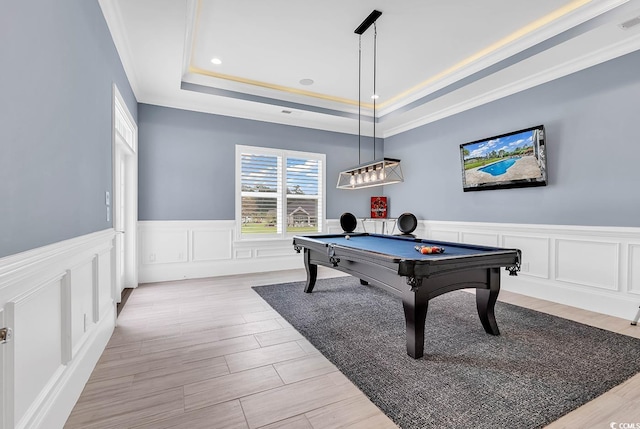 game room with a raised ceiling, ornamental molding, light hardwood / wood-style flooring, and billiards